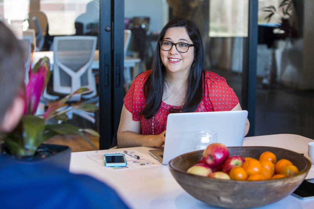 An accounting and business management student talking to someone while working on a laptop