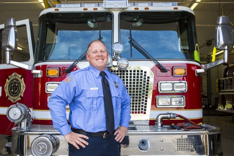 A fire officer standing in front of a fire truck