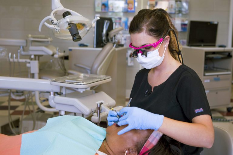 A dental hygienist cleaning a patient's teeth