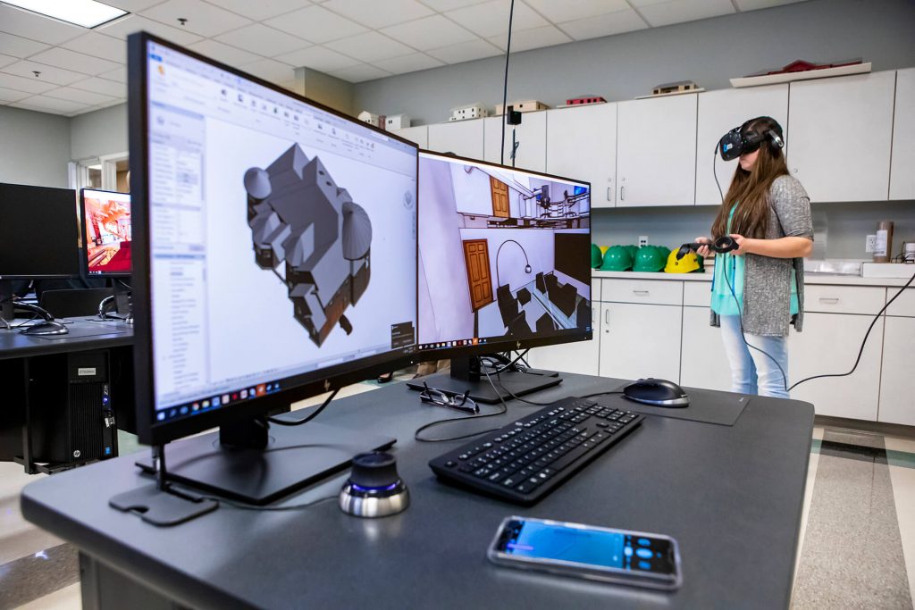 A drafting and design technology student viewing a building model through a virtual reality headset