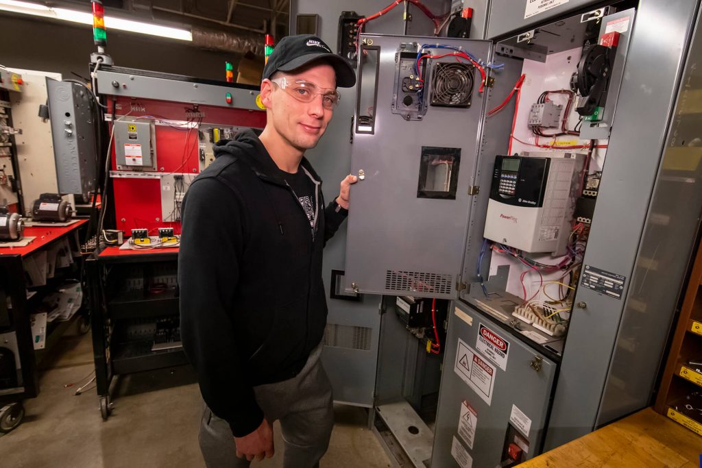 A manufacturing technology student operating manufacturing equipment